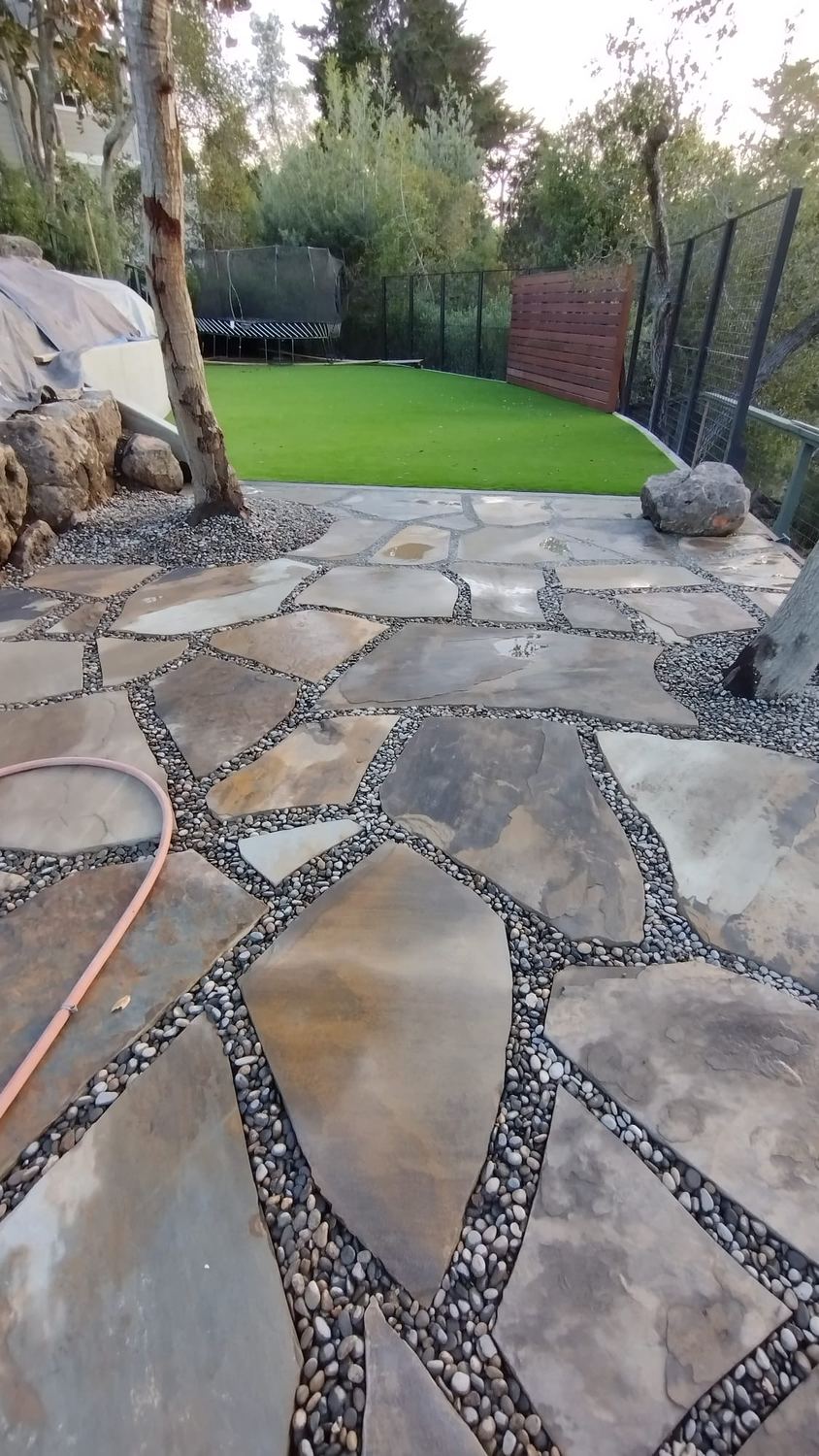 Natural flagstone pathway with decorative river-rock joints.